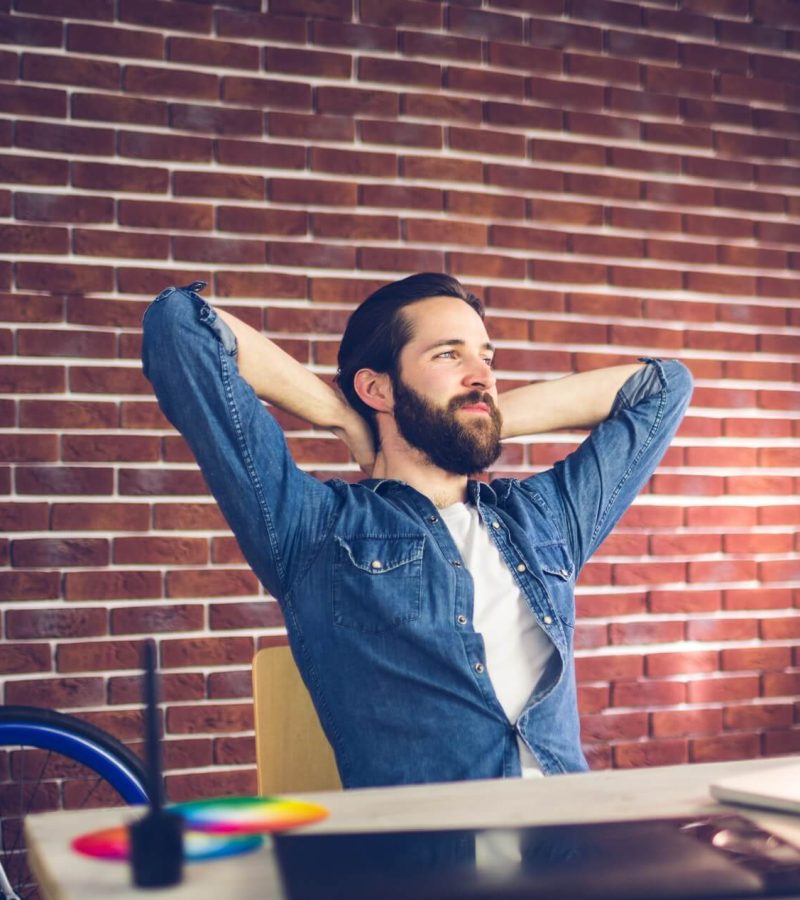 thoughtful-businessman-with-hands-behind-back-relaxing-in-creative-office-1.jpg